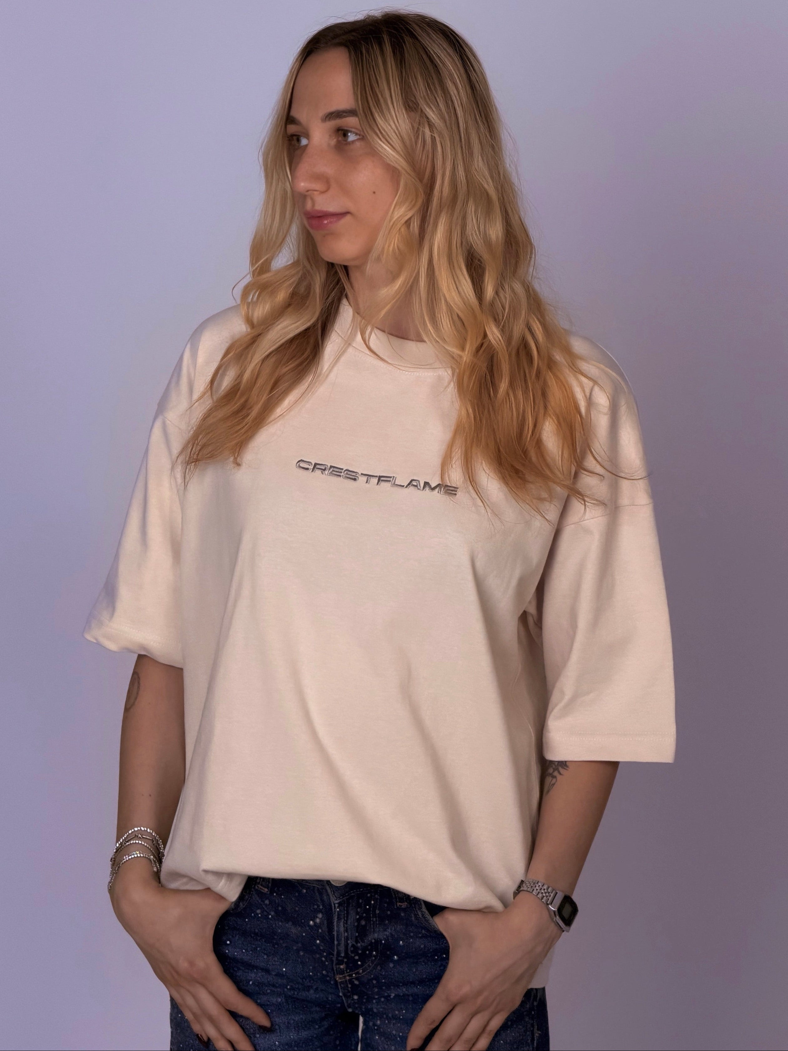 Person wearing a beige t-shirt with text on a plain background