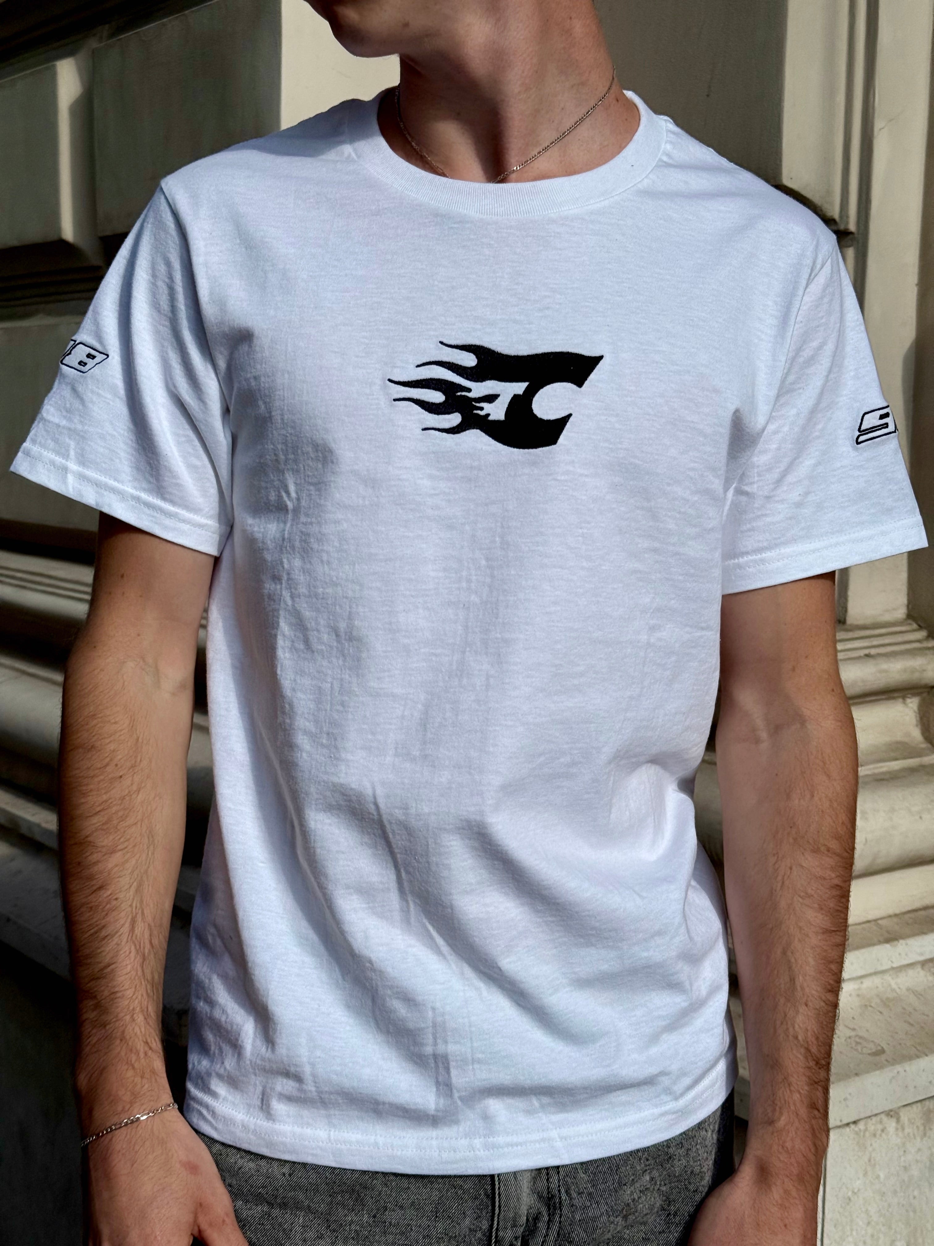 Person wearing a white t-shirt with a black logo on a neutral background