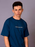 Man wearing a navy blue t-shirt with 'Crest Flame' logo against a gray background